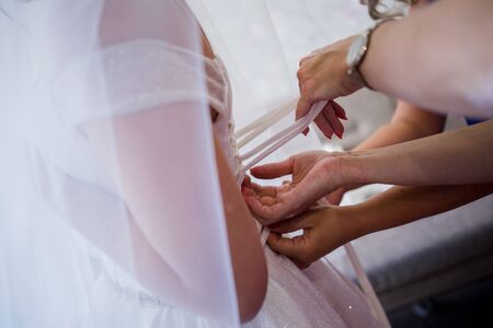 hands of the bride on wedding dress