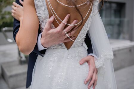 hand of the groom on the back of brideの写真素材