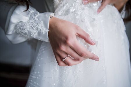 hands of the bride on wedding dressの写真素材