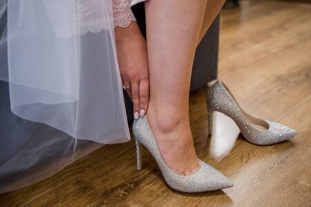 a bride puts on wedding shoesの写真素材