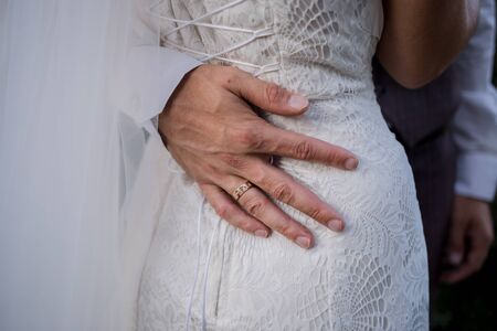 hand of the groom on the waist of the brideの写真素材