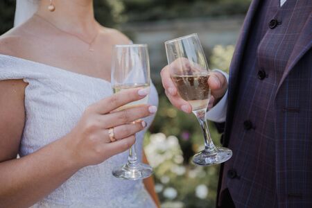 glasses with champagne in hands at weddingの写真素材