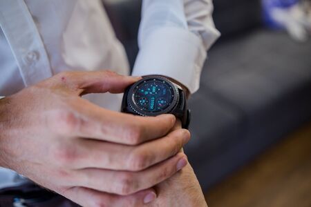 man puts smart watch on his handの写真素材