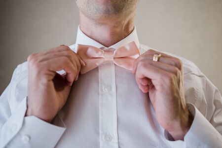 man puts on pink bow tieの写真素材