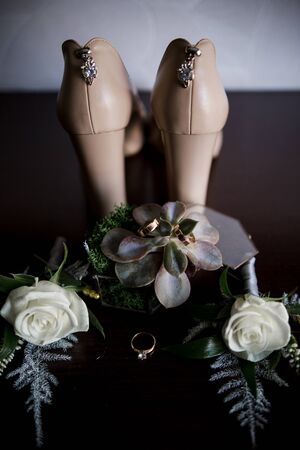 a bride's shoes with wedding rings and decorの写真素材