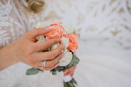 bride holds wedding bouquet in her handsの写真素材