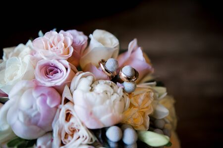 wedding gold rings on bride's bouquetの写真素材