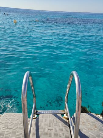 a descent into sea water from the pierの写真素材