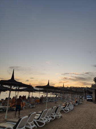 beach near the sea with umbrellas in eveningの写真素材