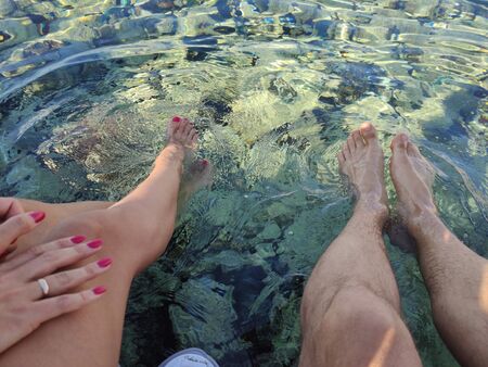 a legs of man and woman in clear sea waterの写真素材