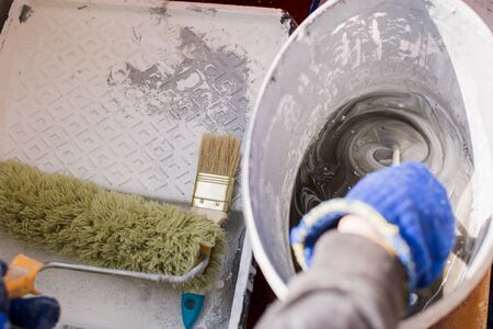 stir the paint with the gloved hand of painterの写真素材