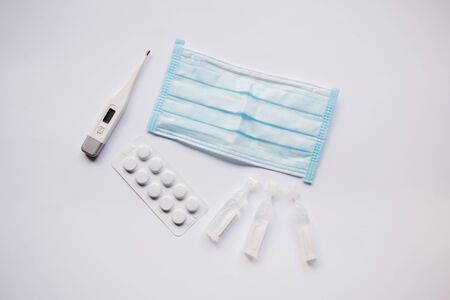 electronic thermometer with a medication and maskの写真素材