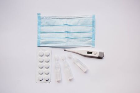 electronic thermometer with a medication and maskの写真素材