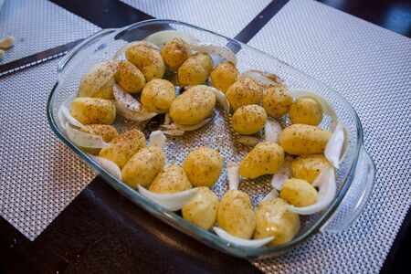 whole potatoes in a dish in kitchenの写真素材