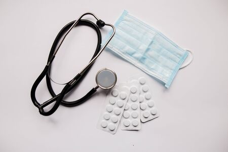 stethoscope pills and mask on a white backgroundの写真素材