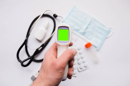 electronic thermometer in hand pills and maskの写真素材