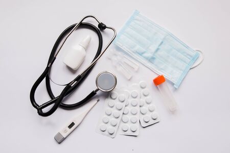 stethoscope pills and mask on a white backgroundの写真素材