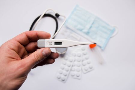 electronic thermometer in hand pills and maskの写真素材