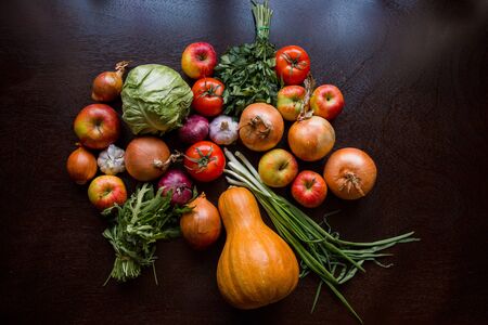 garlic tomato greens and vegetables on the tableの写真素材