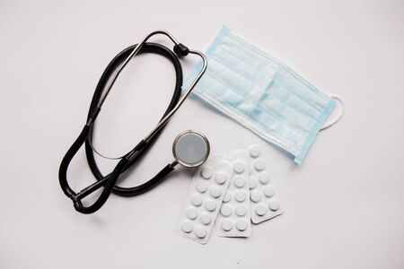 stethoscope pills and mask on a white backgroundの写真素材