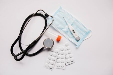 stethoscope pills and mask on a white backgroundの写真素材