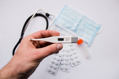 electronic thermometer in hand pills and maskの写真素材