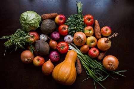garlic tomato greens and vegetables on the tableの写真素材