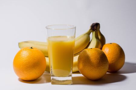 bananas with oranges and glass of juiceの写真素材