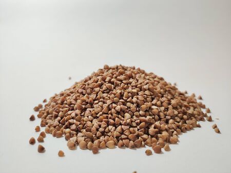 buckwheat in a pile on white backgroundの写真素材
