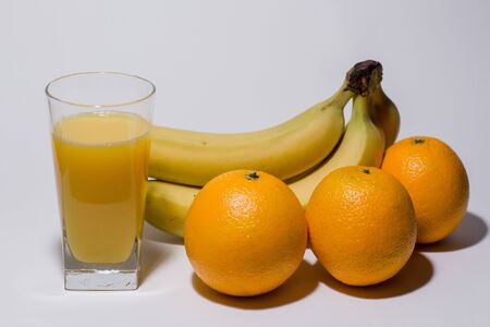 bananas with oranges and glass of juiceの写真素材