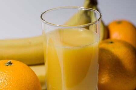 bananas with oranges and glass of juiceの写真素材