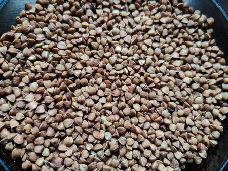 buckwheat in a pile on white backgroundの写真素材