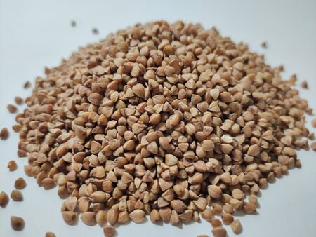 buckwheat in a pile on white backgroundの写真素材