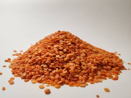 heap of orange lentils on white backgroundの写真素材