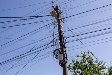 an electric wires on a pillar in a cityの写真素材