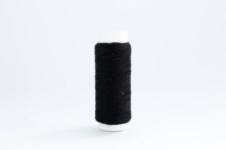 spool of black thread on white backgroundの写真素材