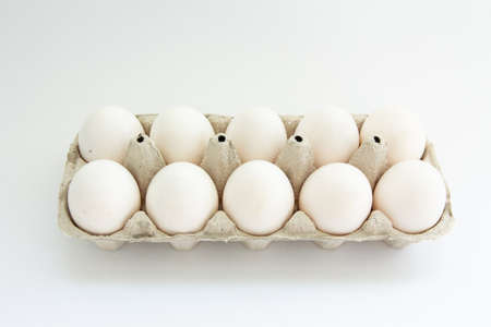 eggs in a tray on white backgroundの写真素材