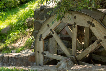 old wooden water pumping wheel on riverの写真素材