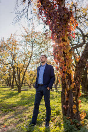 man in suit in the autumn in the parkの写真素材