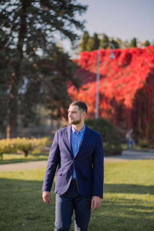 man in suit in the autumn in the parkの写真素材