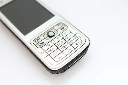 old push-button smartphone on white backgroundの写真素材