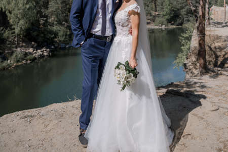 the groom with the bride on the stones near lakeの写真素材