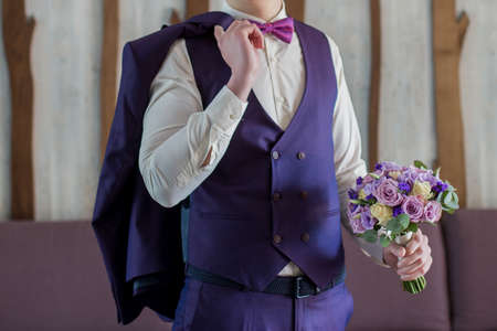 a male businessman putting on blue suitの写真素材