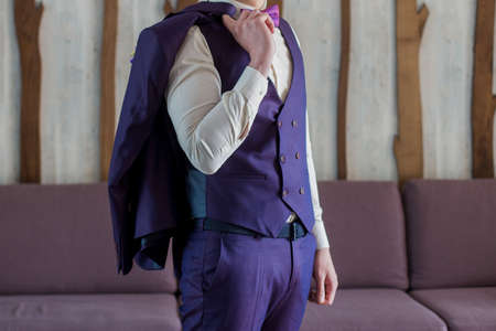 a male businessman putting on blue suitの写真素材