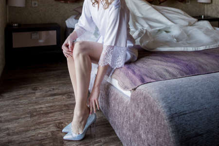 the bride puts shoes on the bed in morningの写真素材