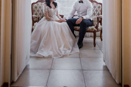 the groom and the bride are sitting on bedの写真素材