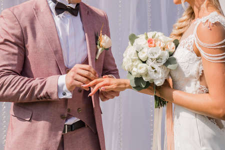 the groom puts ring on the bride's finger