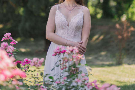 bride in a wedding dress in flowers in parkの写真素材