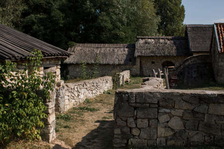 old stone buildings with wooden roof in forestの写真素材