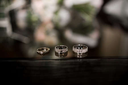 a wedding rings lie on a dark table